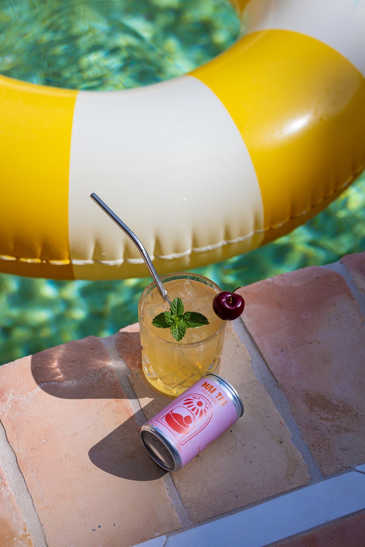 Verre de Mai Tai et canette au pied d'une bouée